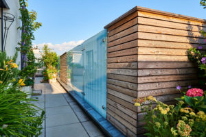 Sichtschutz aus Holz und Glas auf einer Dachterrasse